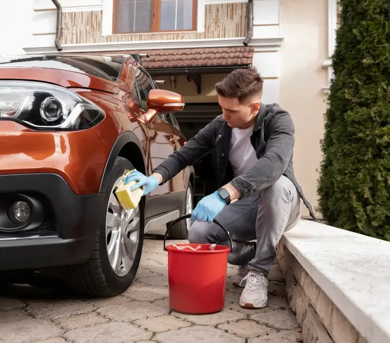 Lavage auto à domicile Corneville-sur-Risle : professionnel intervenant sur un véhicule